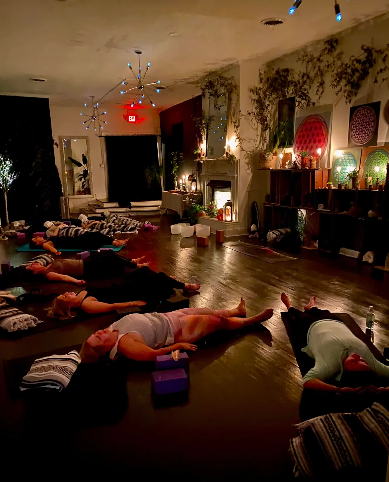 Students resting on mats during a candlelit relaxation practice